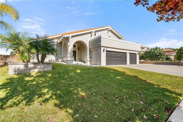 mediterranean / spanish house featuring stucco siding, a front yard, concrete driveway, and an attached garage