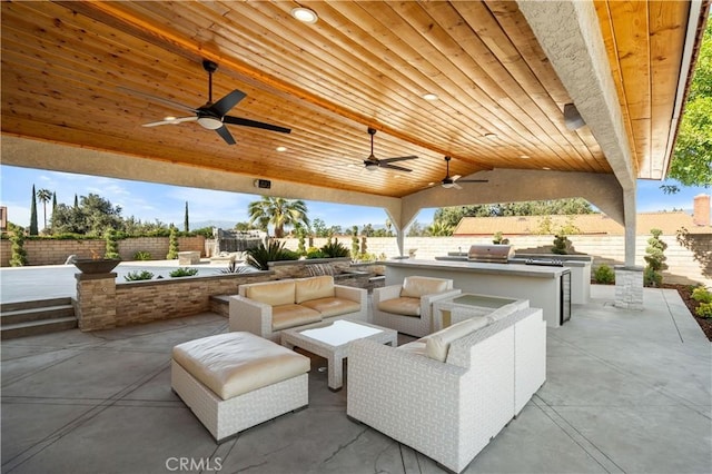 view of patio / terrace featuring an outdoor living space, a fenced backyard, and exterior kitchen