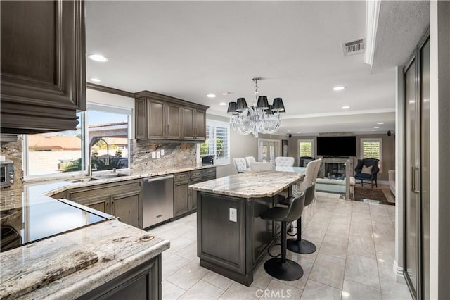 kitchen featuring dishwasher, a center island, backsplash, a notable chandelier, and a breakfast bar area