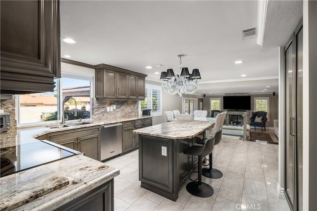 kitchen with a kitchen island, open floor plan, a breakfast bar area, light stone counters, and stainless steel dishwasher