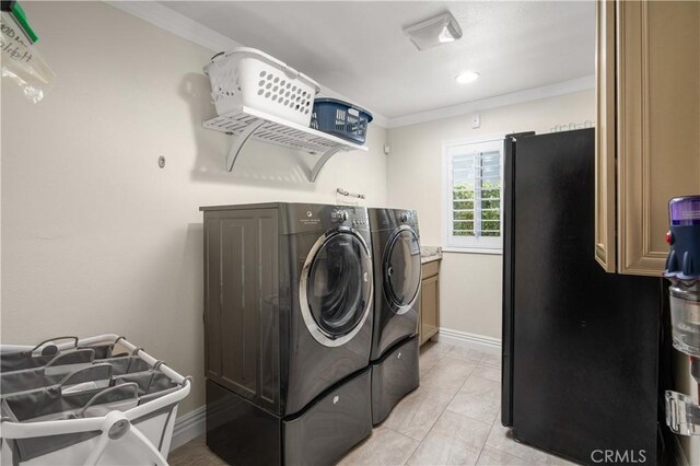 laundry room featuring light tile patterned flooring, washing machine and dryer, and ornamental molding