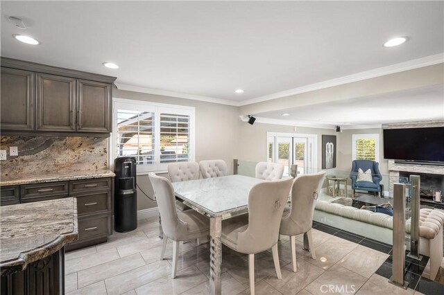 dining room with crown molding, light tile patterned floors, and french doors