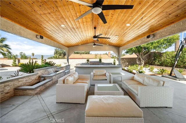 view of patio with ceiling fan, an outdoor living space, and an outdoor kitchen