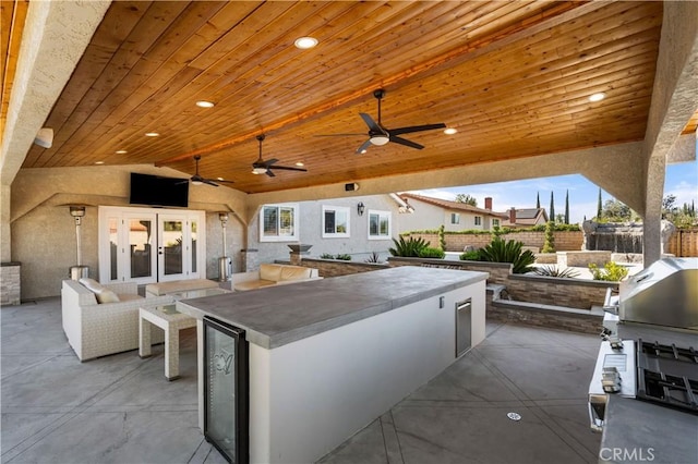 view of patio featuring a ceiling fan, beverage cooler, fence, area for grilling, and french doors