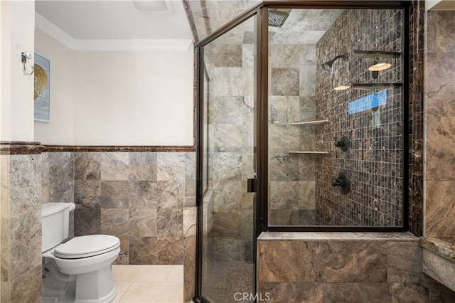 bathroom with a stall shower, toilet, tile walls, and ornamental molding