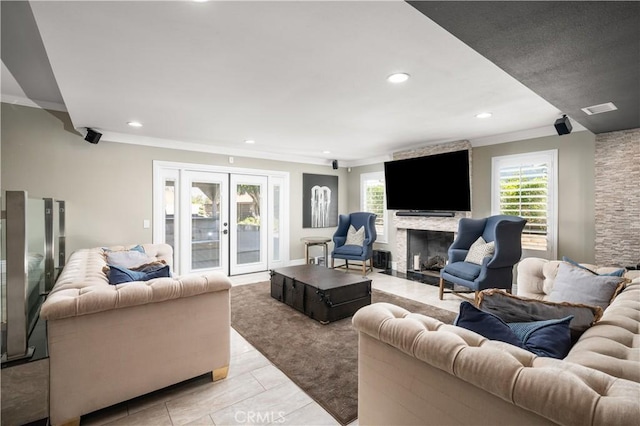 living room featuring recessed lighting, french doors, a large fireplace, and a healthy amount of sunlight