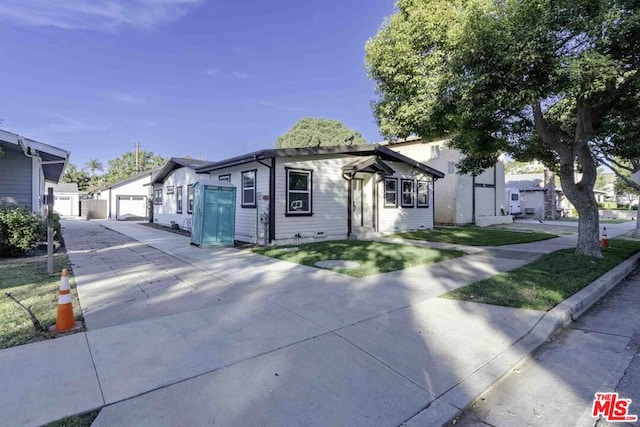 view of front of home with a garage and an outbuilding