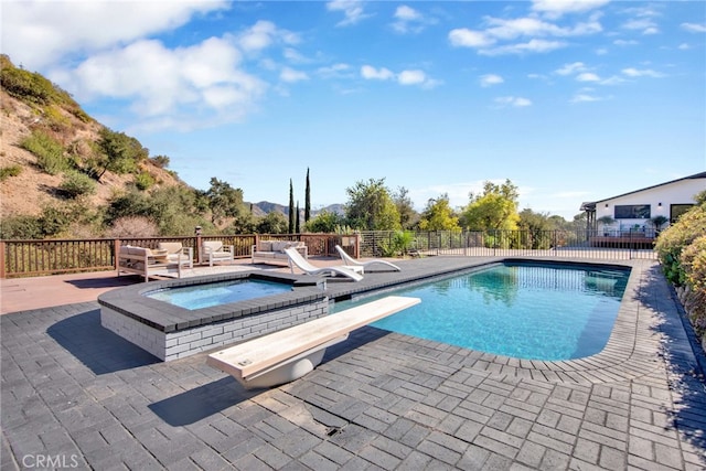 view of swimming pool with a diving board, a patio, and an in ground hot tub