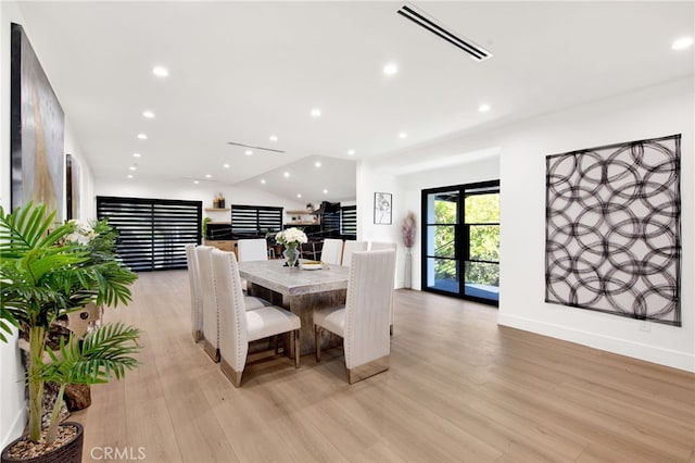 dining room featuring light hardwood / wood-style floors and vaulted ceiling