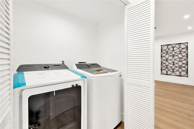 laundry room with light hardwood / wood-style floors and washing machine and dryer