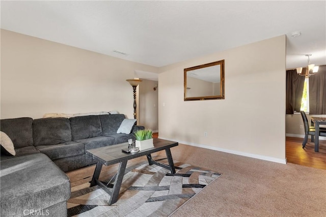 carpeted living room with a chandelier