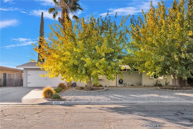 view of property hidden behind natural elements with a garage