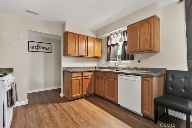 kitchen featuring sink, dark hardwood / wood-style floors, and white appliances