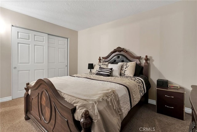 bedroom with a closet, dark carpet, and a textured ceiling