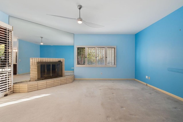 unfurnished living room with carpet, a brick fireplace, ceiling fan, and a healthy amount of sunlight