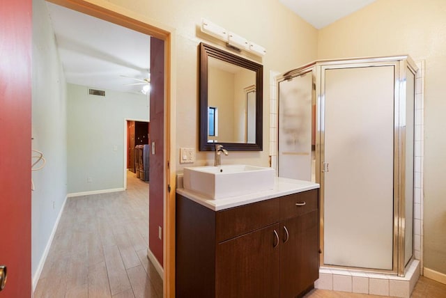 bathroom featuring ceiling fan, walk in shower, washer / clothes dryer, vanity, and hardwood / wood-style flooring