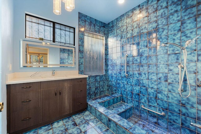 bathroom featuring a tile shower, vanity, and tile patterned floors