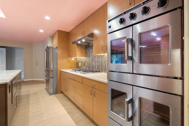 kitchen with decorative backsplash, light hardwood / wood-style floors, range hood, and appliances with stainless steel finishes