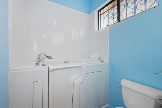 bathroom featuring a bath and toilet