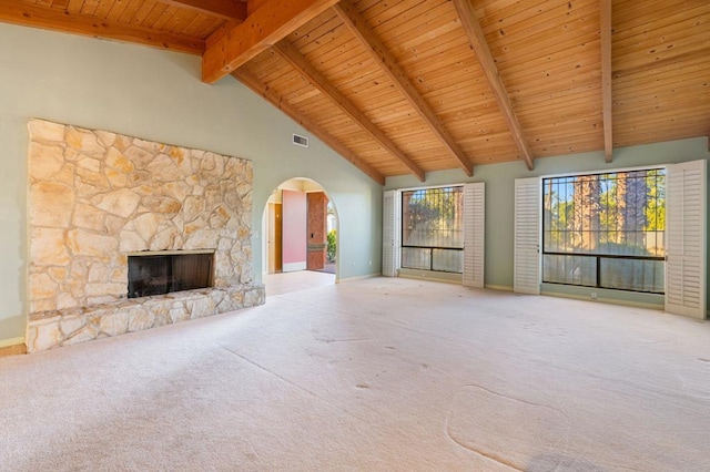 unfurnished living room featuring a fireplace, beam ceiling, carpet floors, and high vaulted ceiling