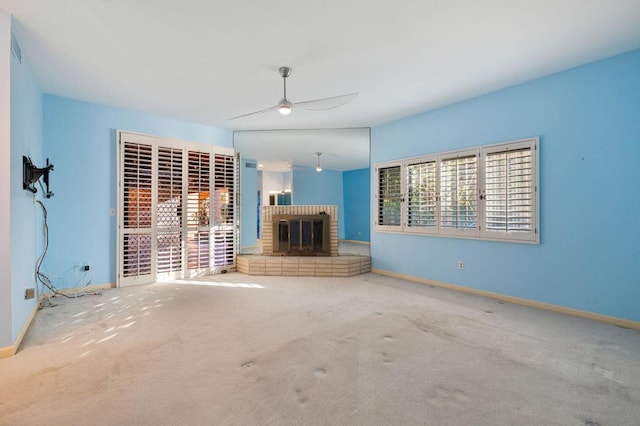 unfurnished living room featuring ceiling fan, carpet, and a brick fireplace