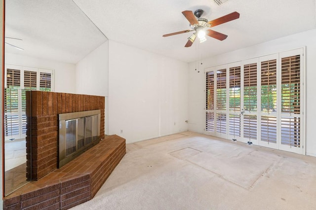 unfurnished living room featuring ceiling fan, lofted ceiling, light carpet, and a brick fireplace