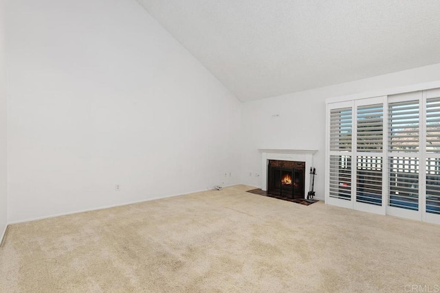 unfurnished living room with high vaulted ceiling and carpet flooring