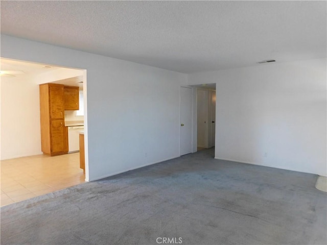 carpeted empty room featuring a textured ceiling