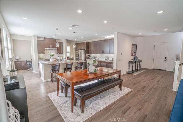 dining space featuring plenty of natural light, wood-type flooring, and sink