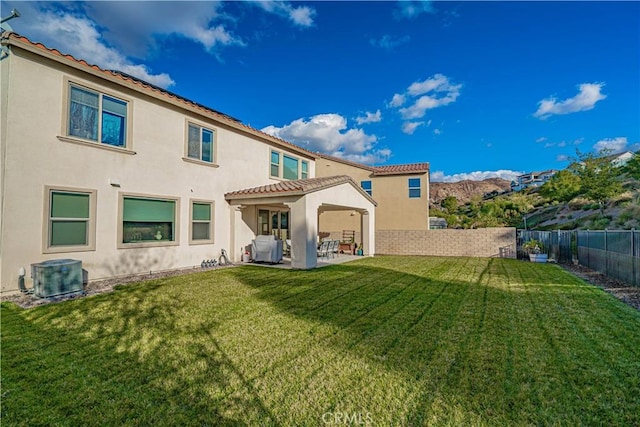 rear view of house featuring a mountain view, a yard, and central AC