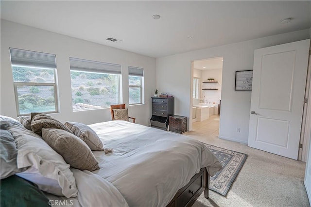 carpeted bedroom featuring ensuite bathroom