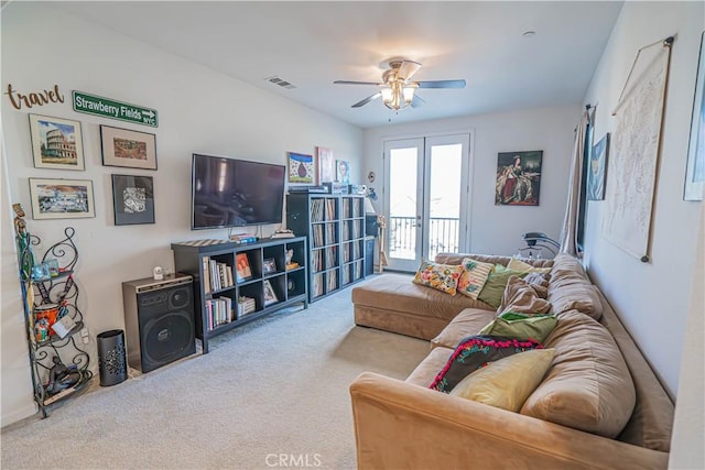 carpeted living room with french doors and ceiling fan