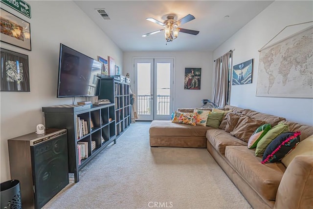 carpeted living room with french doors and ceiling fan