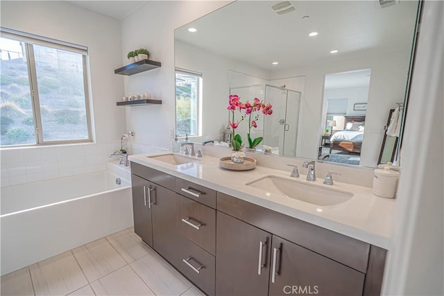 bathroom with tile patterned flooring, vanity, and separate shower and tub