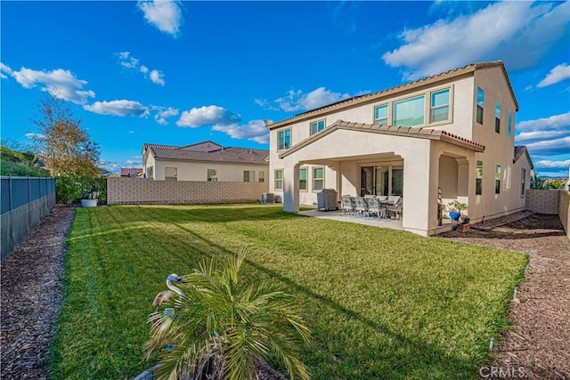 back of house with a yard and a patio