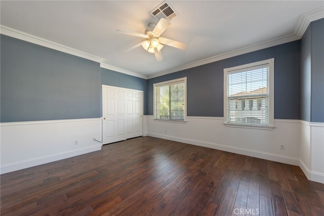 empty room with ceiling fan, a healthy amount of sunlight, dark hardwood / wood-style flooring, and crown molding