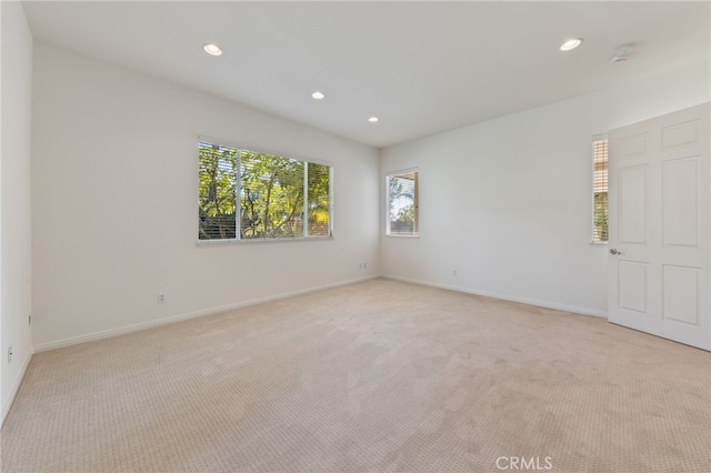 empty room with light colored carpet and a wealth of natural light