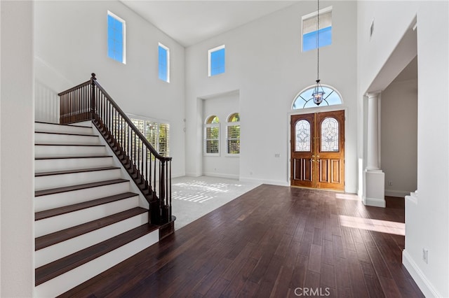 entrance foyer featuring dark wood-type flooring, a high ceiling, and french doors