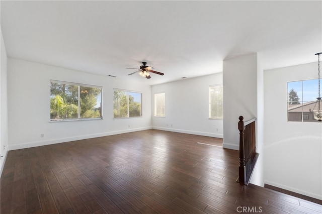 unfurnished living room featuring plenty of natural light, ceiling fan, and dark wood-type flooring