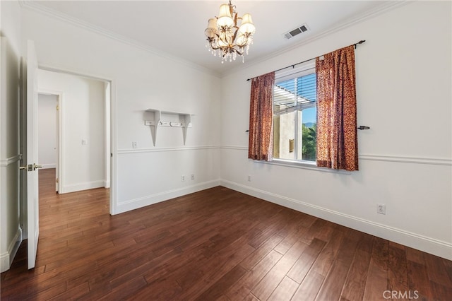 spare room featuring crown molding, dark hardwood / wood-style flooring, and an inviting chandelier