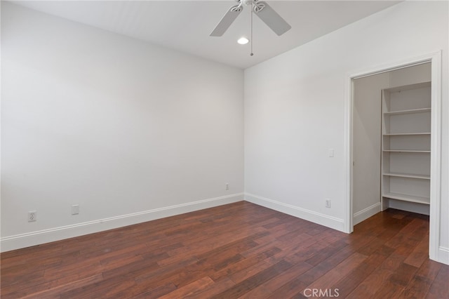 empty room featuring ceiling fan and dark wood-type flooring