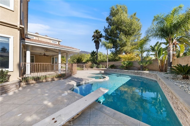 view of pool featuring a diving board, a patio area, ceiling fan, and an in ground hot tub