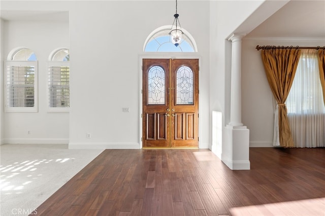 entryway featuring decorative columns, dark hardwood / wood-style flooring, a chandelier, and french doors