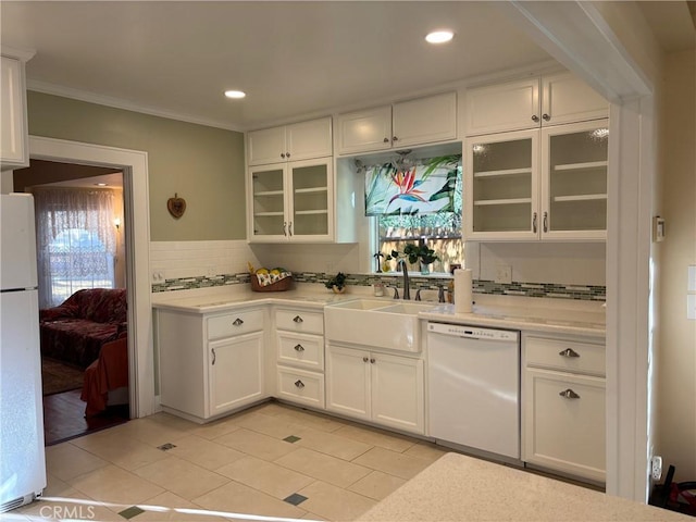 kitchen featuring tasteful backsplash, white cabinets, crown molding, white appliances, and light tile patterned floors