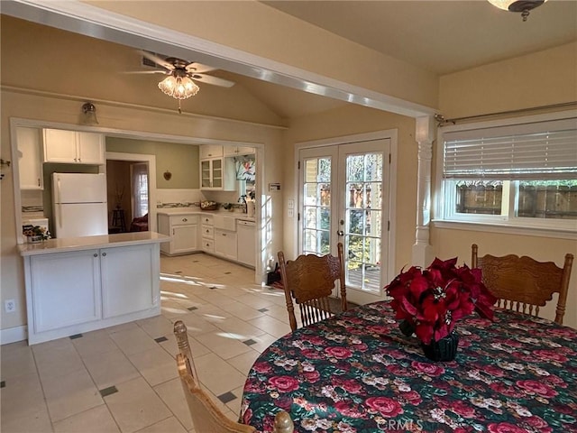 dining area featuring ceiling fan, lofted ceiling, light tile patterned floors, and french doors