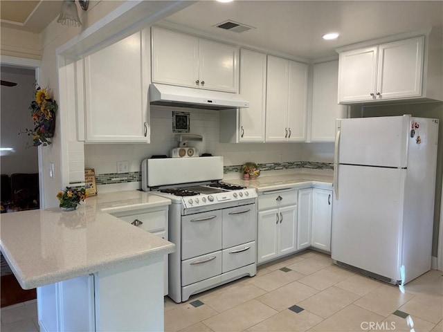 kitchen featuring kitchen peninsula, light tile patterned floors, white appliances, and white cabinetry