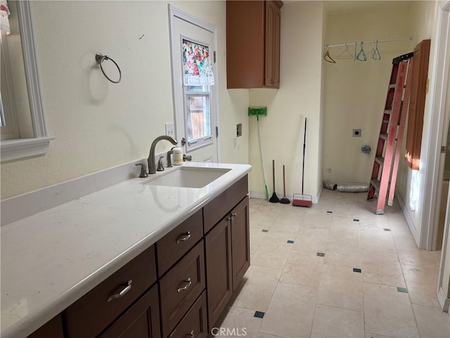 kitchen featuring dark brown cabinets, light tile patterned floors, and sink