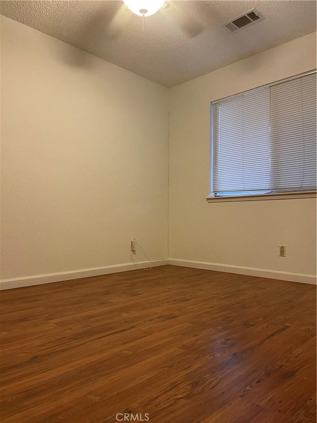 empty room featuring dark hardwood / wood-style floors and a textured ceiling