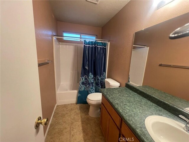 full bathroom with shower / bath combo, vanity, tile patterned flooring, toilet, and a textured ceiling