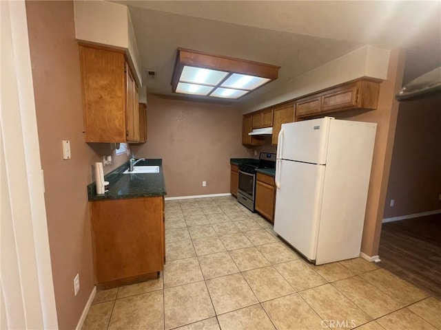 kitchen with sink, white fridge, stainless steel range oven, and light tile patterned floors